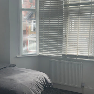 A Bedroom with grey bedding and white blinds in one of our developments